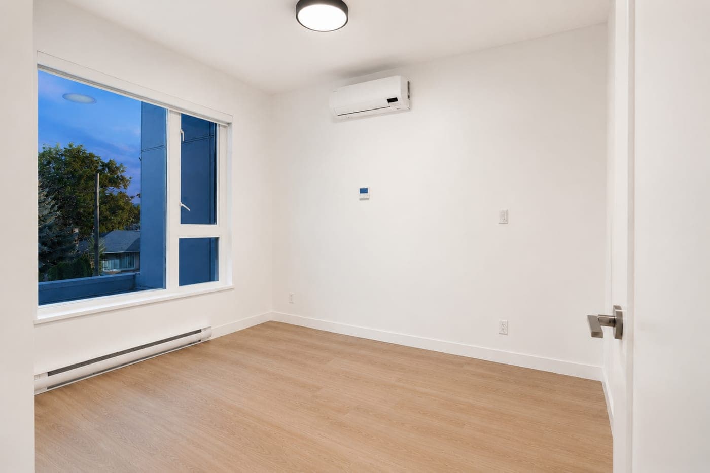 Bedroom with a corner window — empty room, before staging