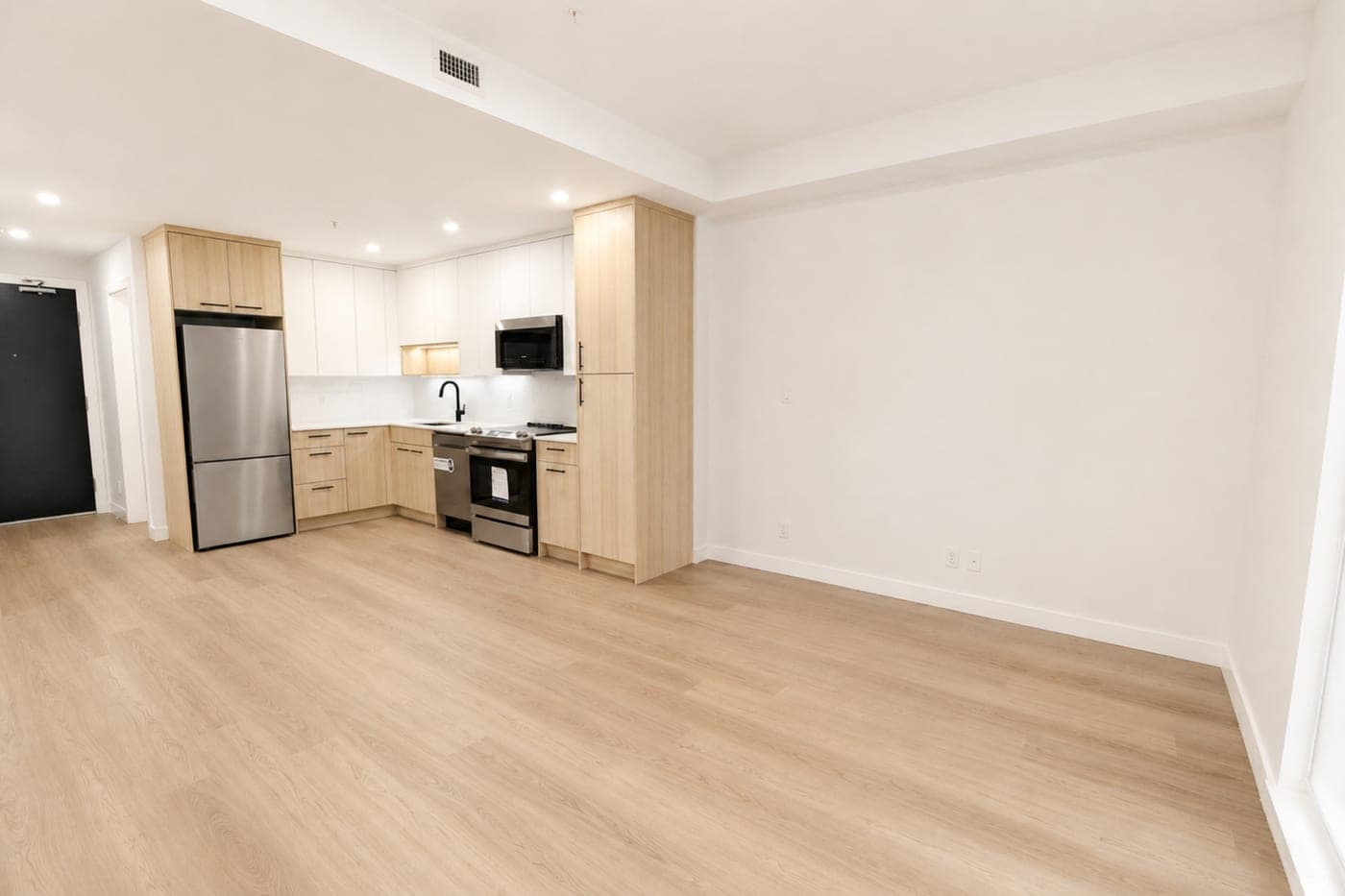 Open living room and kitchen — empty room, before staging